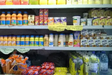 Vendedor a servir leite fresco num mercado local na Uganda